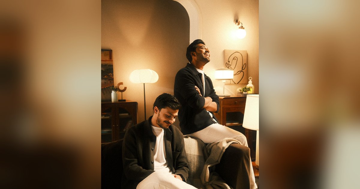 Garvit Soni and Priyansh Srivastava in a lamp-lit living room, one seated smiling and one leaning back laughing