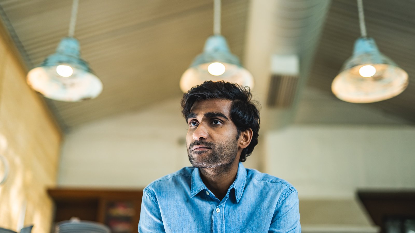 Singer-songwriter Prateek Kuhad performing on stage with a guitar under stage lights