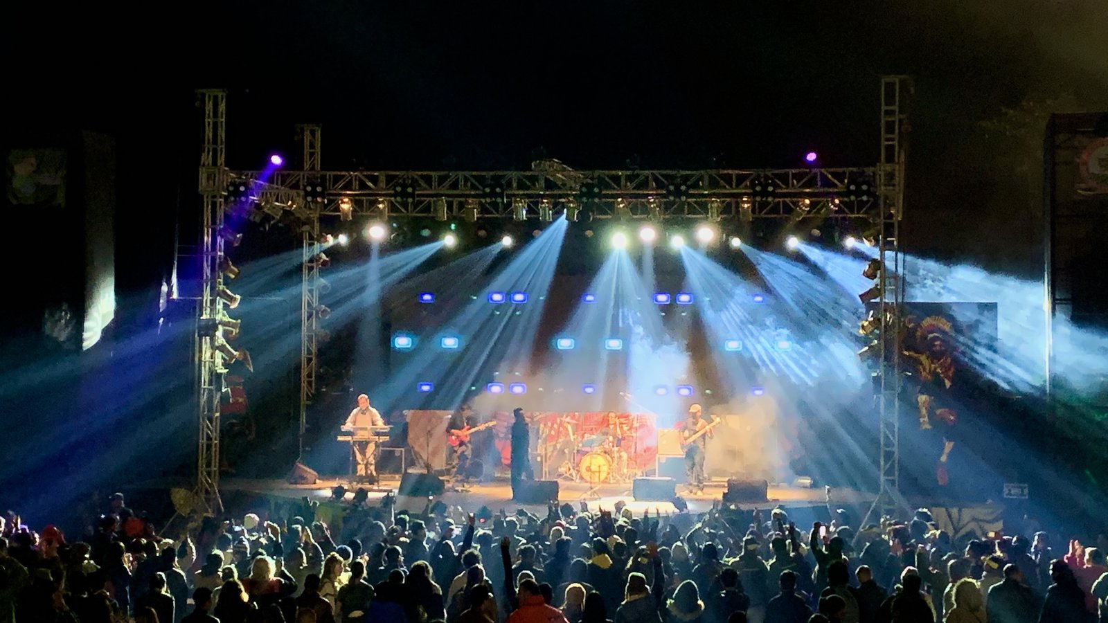 A rock band performs under blue stage lights before a packed crowd at the Hornbill Festival main arena in Kisama, Nagaland, in 2019