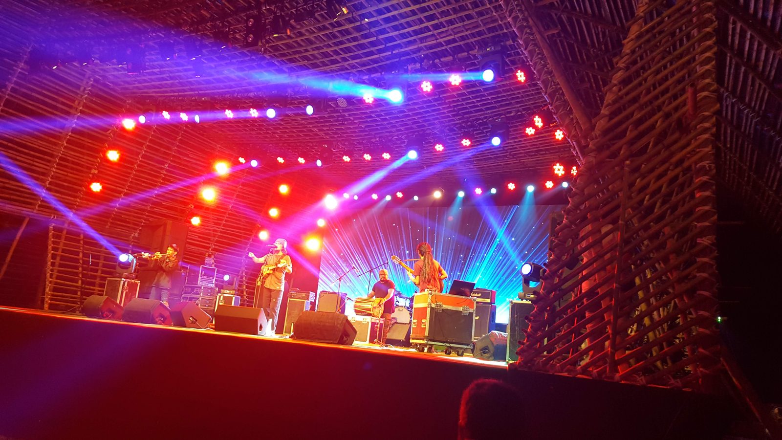 Siyon Ensemble from Imphal perform on the bamboo-framed main stage at Ziro Festival of Music 2019 in Arunachal Pradesh under red and blue lights