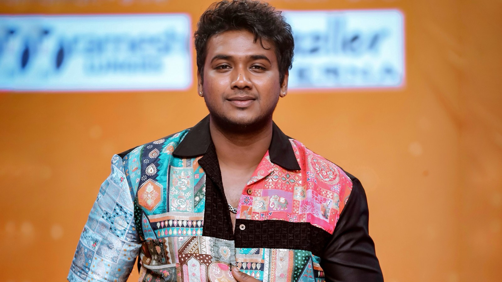 Telugu singer Rahul Sipligunj in a colourful patchwork shirt on the stage of Super Singer Telugu in 2024