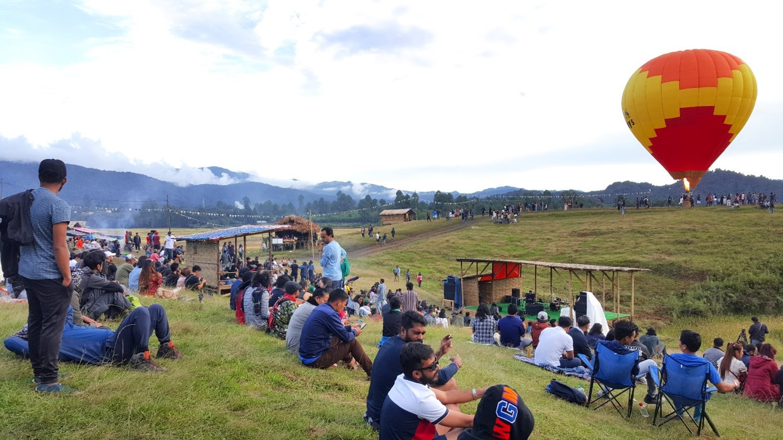 A performer on the day stage at Ziro Festival of Music in Arunachal Pradesh in 2019, with the audience on the grass in front