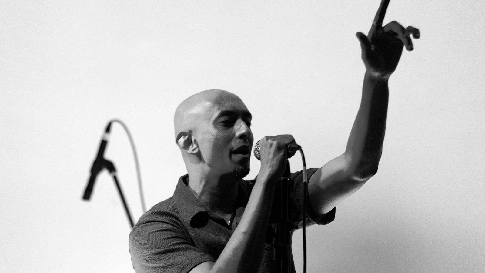 Avial singer Tony John performing with a microphone and raised arm at Kyra Theatre, Bengaluru, in 2009